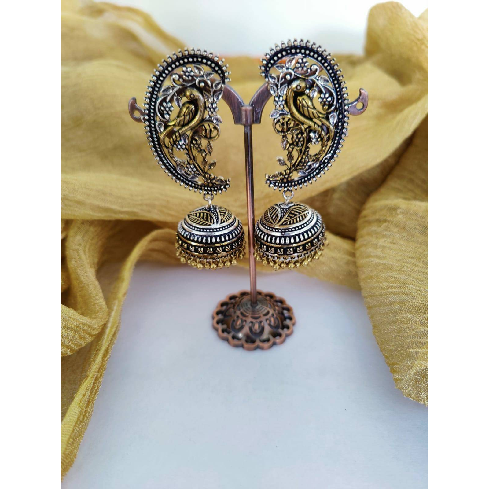 A stunning pair of jhumkis is always a must-have in Indian attire. Especially, white ethnics have long favored oxidized silver jewelry, and we're certain that these oxidized ghungroo jhumkis will be all you need to complete your look. Dreamy ghungroos by the edge of these oxidized earrings and delicate flower embellishments adorn this appealing set of Indian silver jewelry. It's a unique set of Indian earrings that tells a story about your outfit. Because all of our Indian jewelry is handmade, t