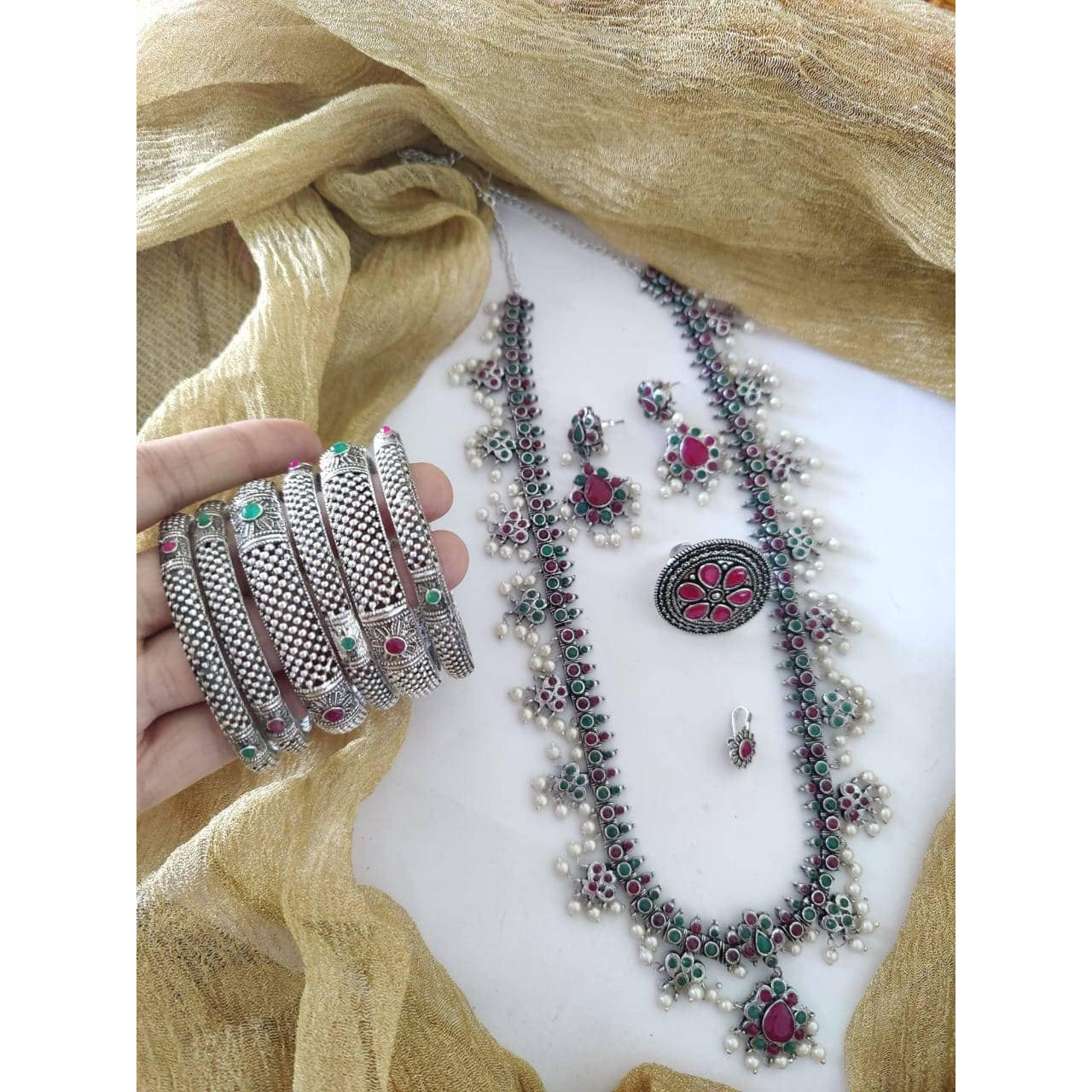 It can't get bolder than this Channelize your inner gypsy and flaunt your style with this bold yet chunky choker necklace set. Crafted in oxidized silver featuring intricate floral detailing with pearl danglers, this necklace set will only lace your neckline perfectly