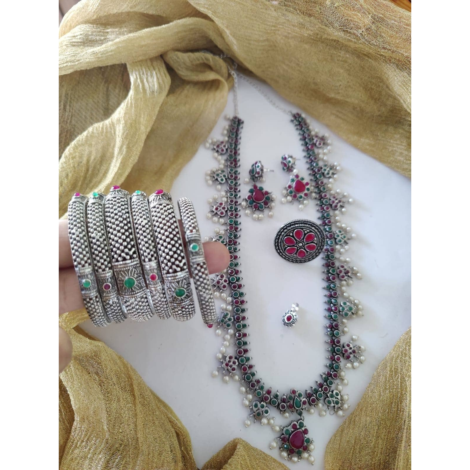 It can't get bolder than this! Channelize your inner gypsy and flaunt your style with this bold yet chunky choker necklace set. Crafted in oxidized silver featuring intricate floral detailing with pearl danglers, this necklace set will only lace your neckline perfectly!