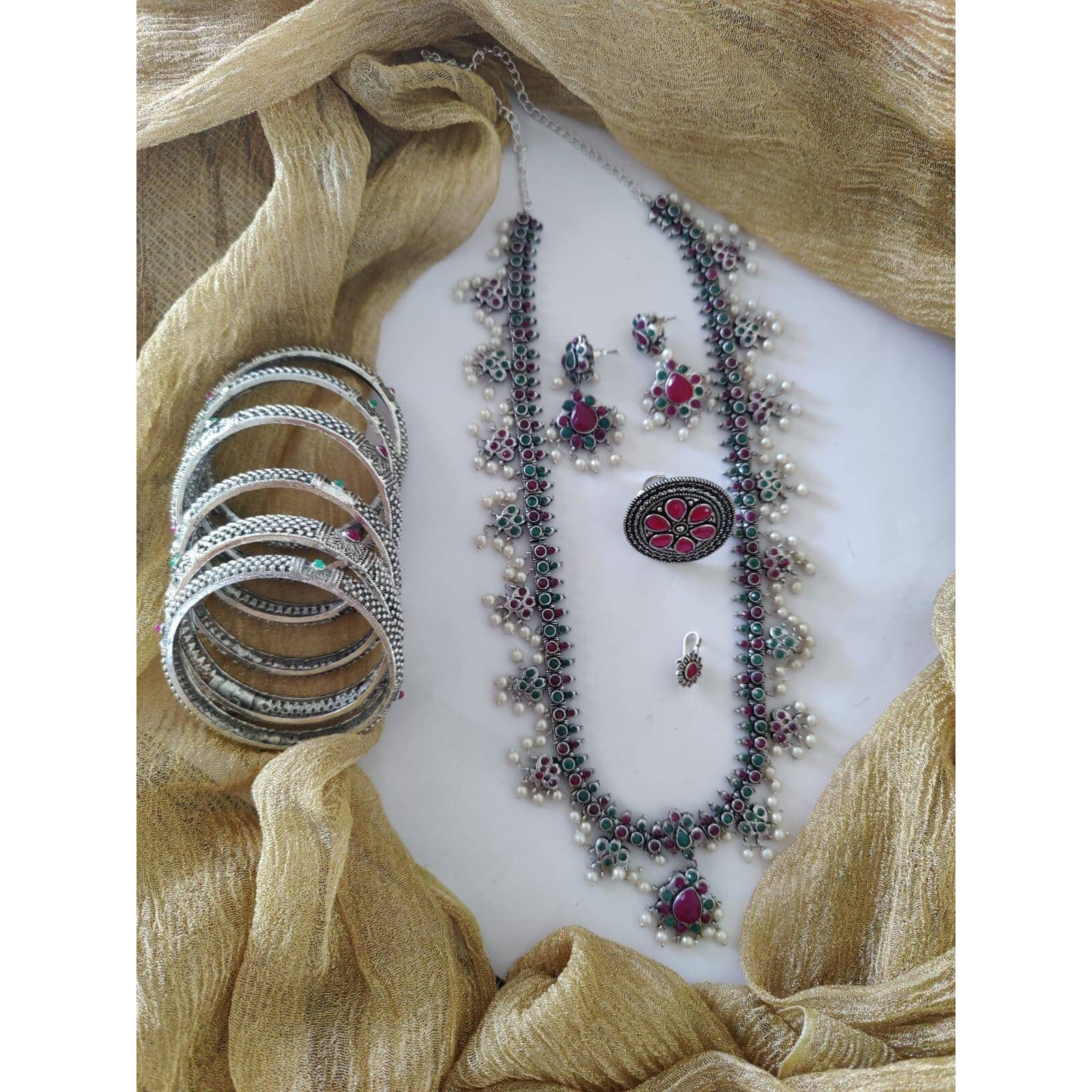 It can't get bolder than this Channelize your inner gypsy and flaunt your style with this bold yet chunky choker necklace set. Crafted in oxidized silver featuring intricate floral detailing with pearl danglers, this necklace set will only lace your neckline perfectly