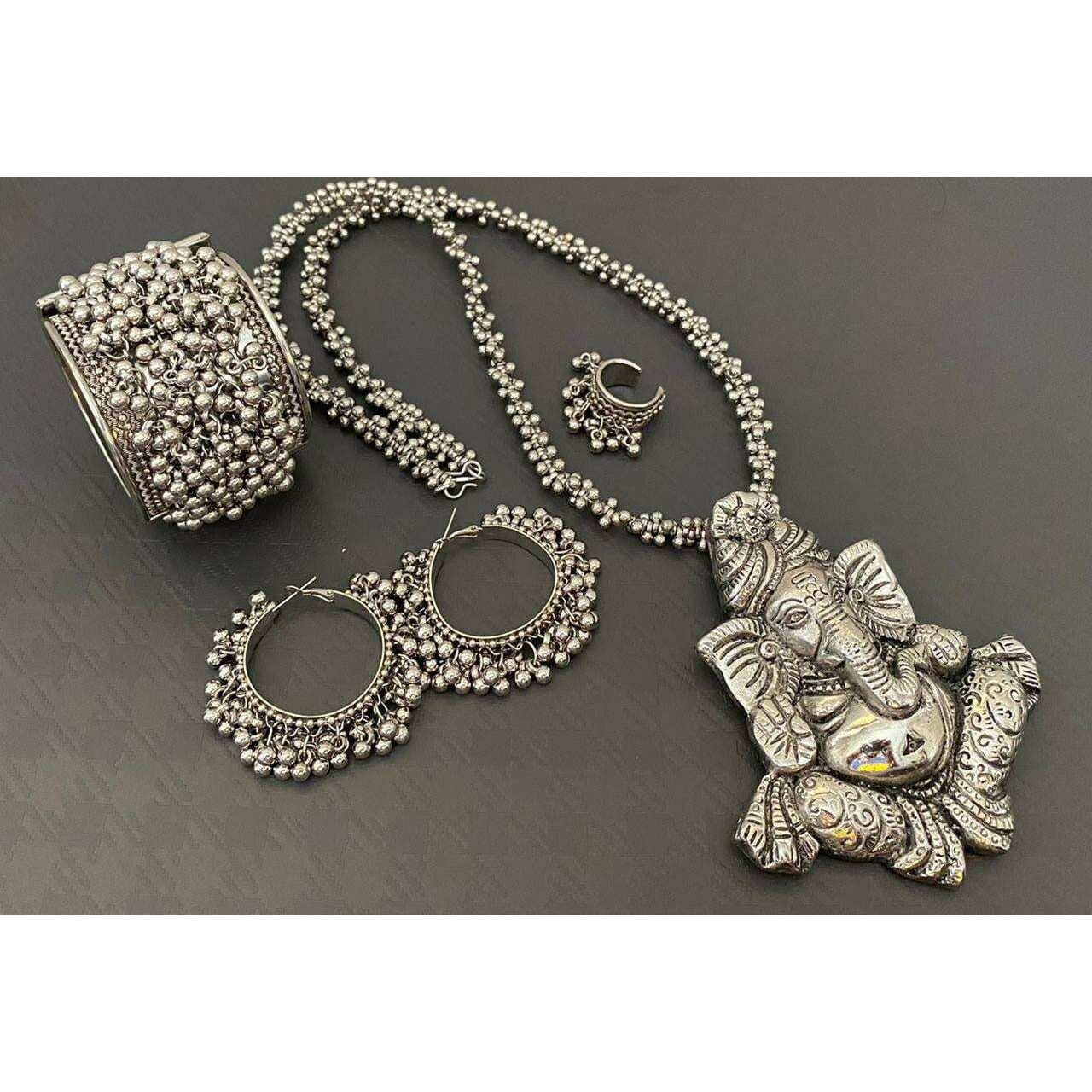 This beautiful set of 6 has a big long oxidized Haram necklace with a choker silver necklace, pair of jhumka earrings, a ring,pair of bangles, and a nose pin.Grab this beautiful set with any of the ethnic/ Indo western outfit and look unique in the crowdPremium quality set