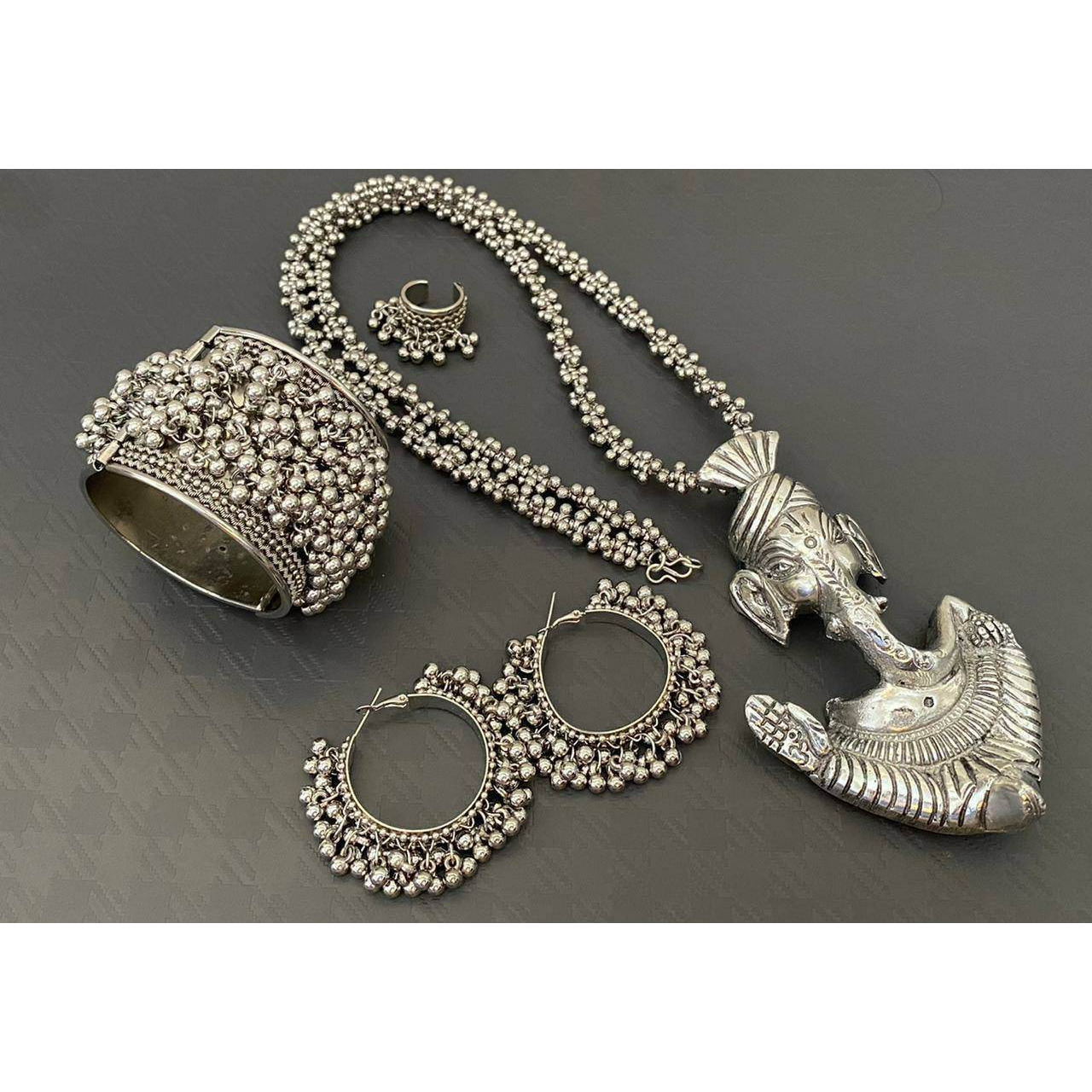 This beautiful set of 6 has a big long oxidized Haram necklace ith a choker silver necklace, pair of jhumka earrings, a ring,pair of bangles, and a nose pin.Grab this beautiful set ith any of the ethnic/ Indo estern outfit and look unique in the crodPremium quality set