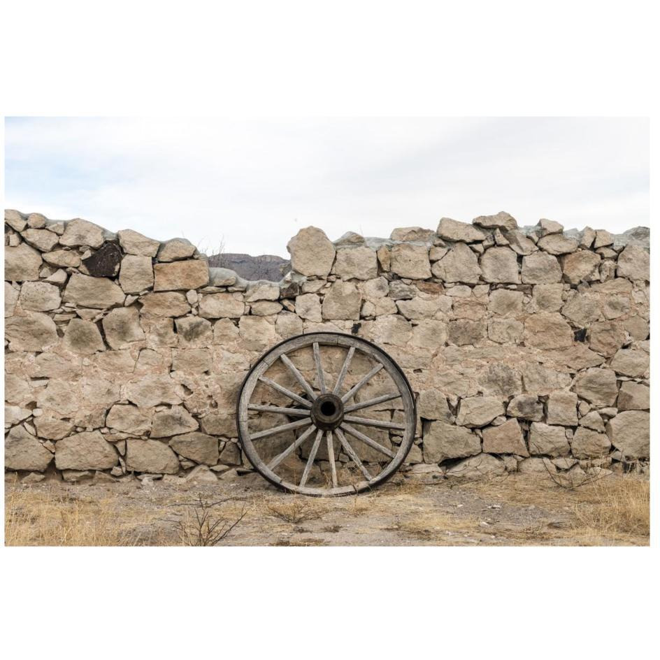 Wagon wheel against a stone fence at Hueco Tanks State Park, northwest of El Paso, TX-Paper Art-26&quotx18"